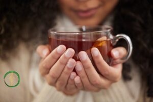 naturalne metody na infekcje pęcherza - młoda kobieta pije moczopędną ziołową herbatkę